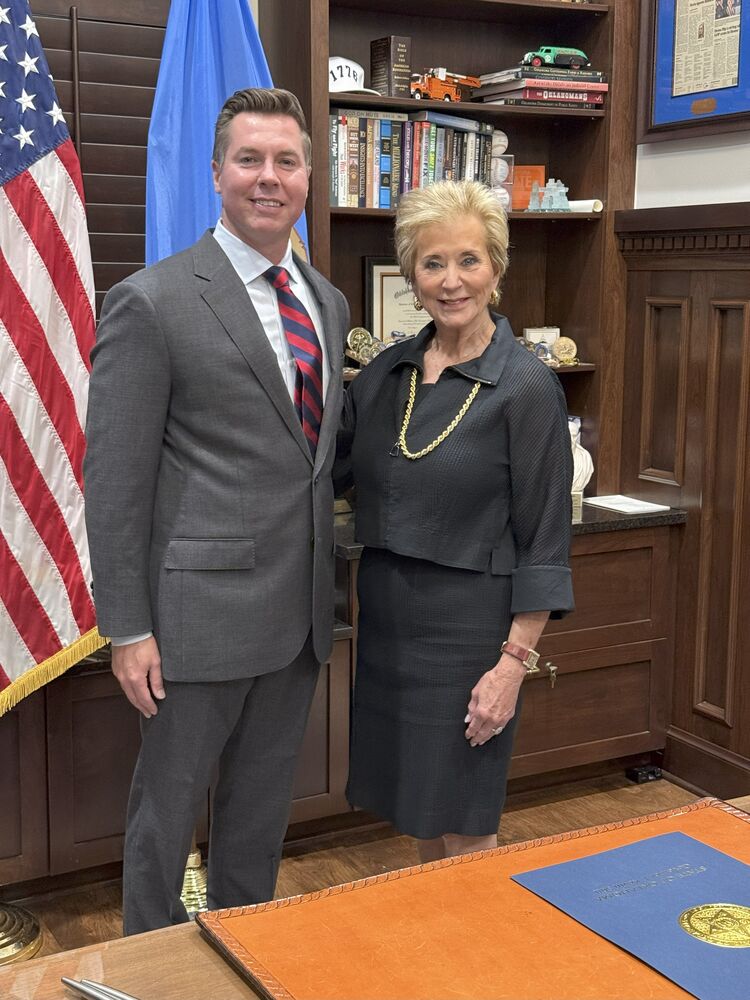 Senator Adam Pugh stands with U.S. Secretary of Education Linda McMahon during the ceremonial bill signing for Senate Bill 796.