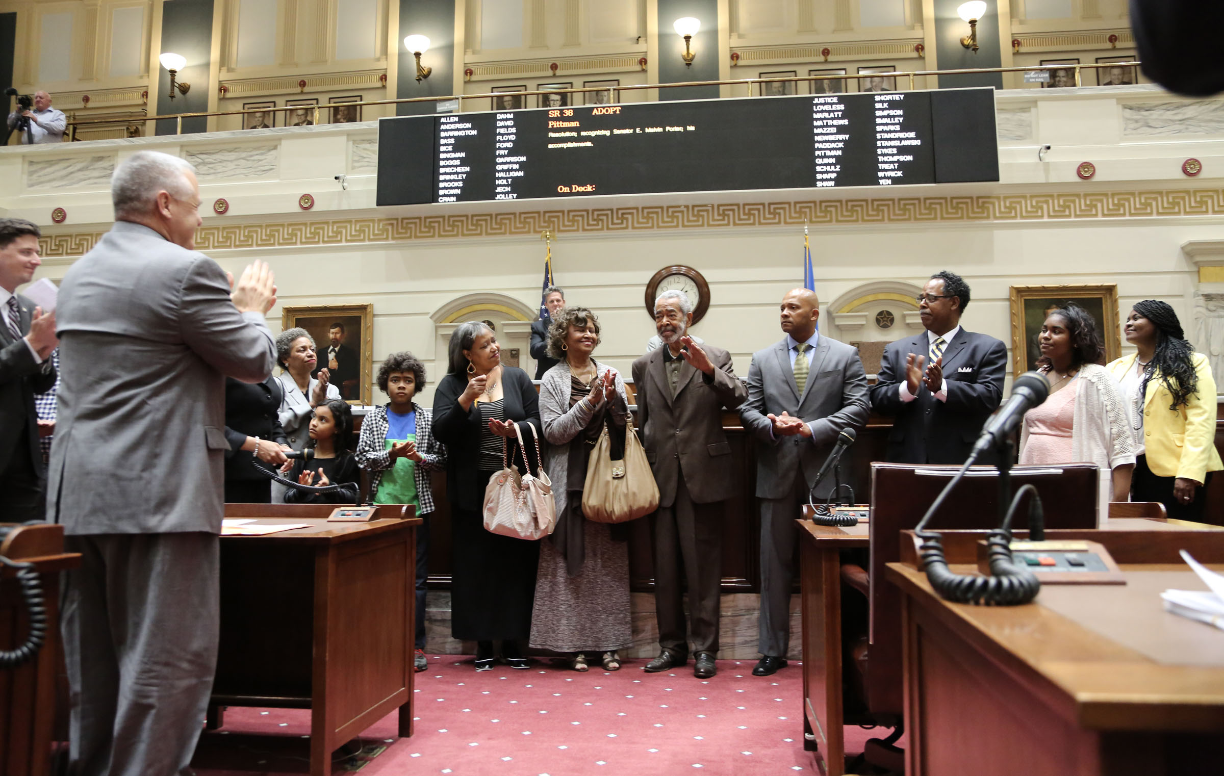 E. Melvin Porter, (center) surrounded by family, received a standing ovation from members of the State Senate during a 2015 ceremony, fifty years after Porter began his service as Oklahoma’s first black senator.