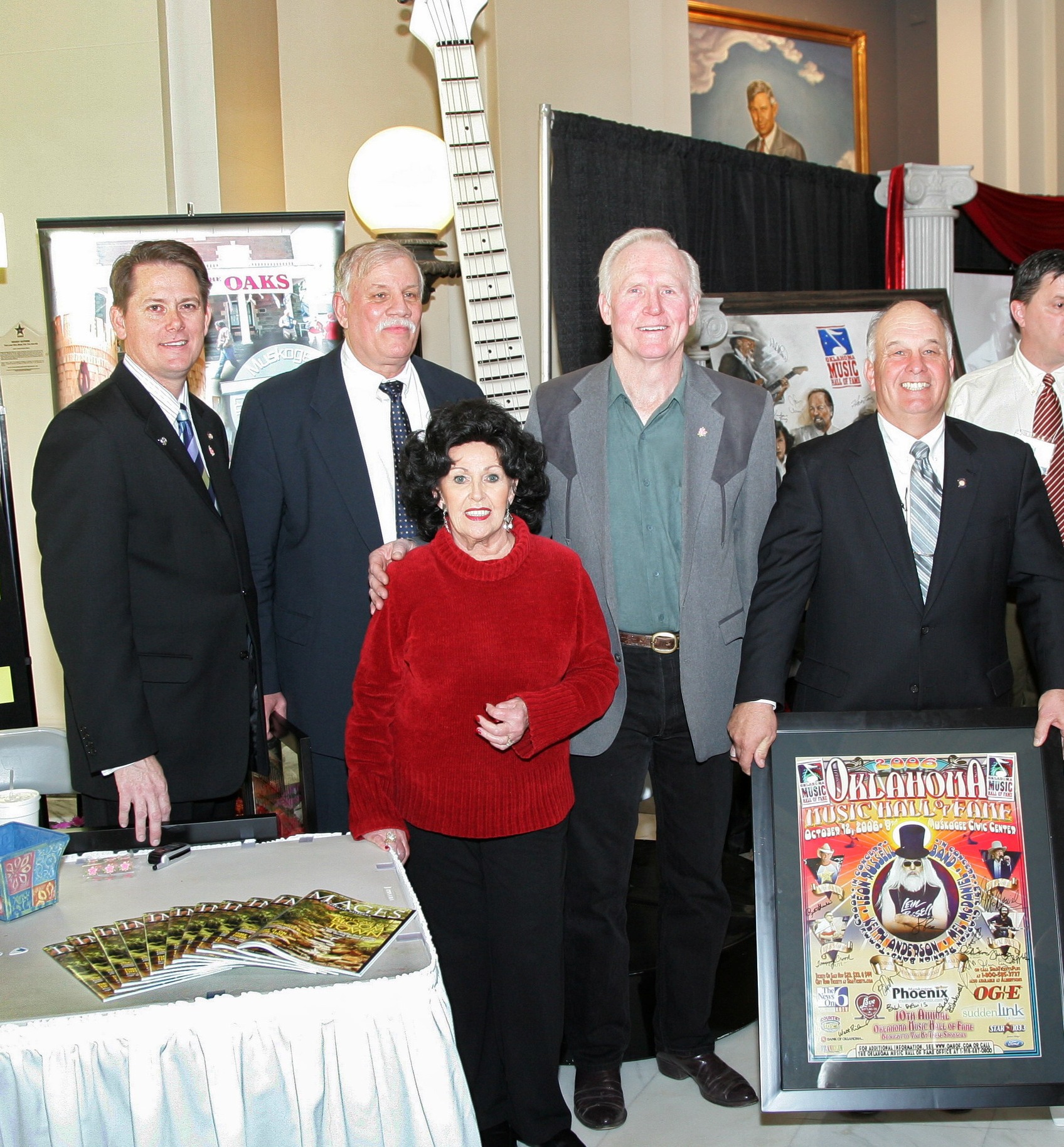 Rep. George Fraught, Sen. Earl Garrison, Wanda Johnson, Byron Berline and Rep. Jerry McPeak pose in front of an 8-foot Telecaster guitar and with a Oklahoma Music Hall of Fame poster.