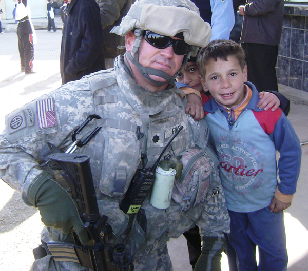 Col. William Finley poses with Iraqi children in Tal A‘Far, Iraq.