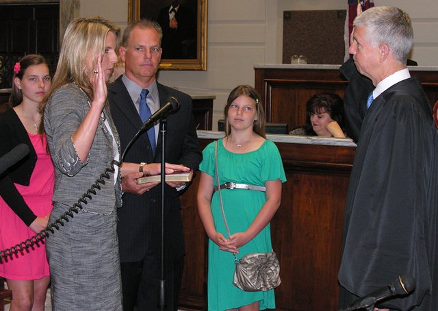 Sen AJ Griffin surrounded by daughters Alexandra Reagan and husband Trey is sworn in by Chief Justice Steve Taylor.