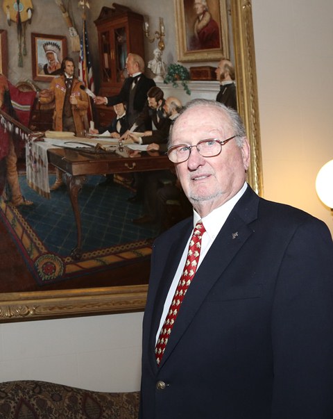 Sen. Charles Ford poses in front of painting of Osage Treaty of 1825.