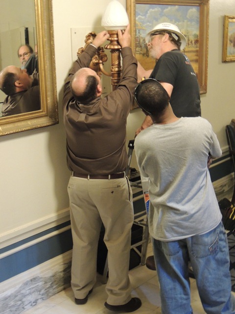 Workers install sconces.
